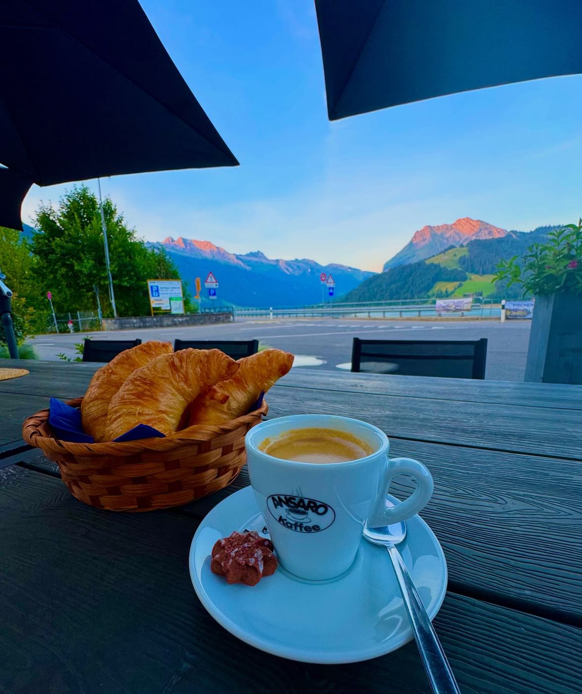 Kafi und Gipfeli auf der Terrasse des Bistro am See, die Berge im Morgenrot